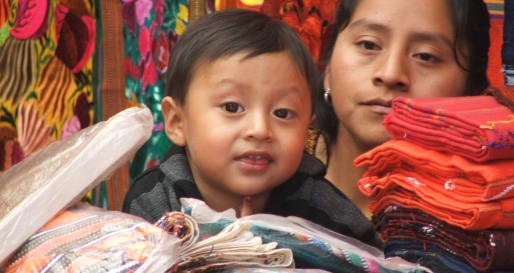 Guatemalan lady selling woven fabrics at Chichi 