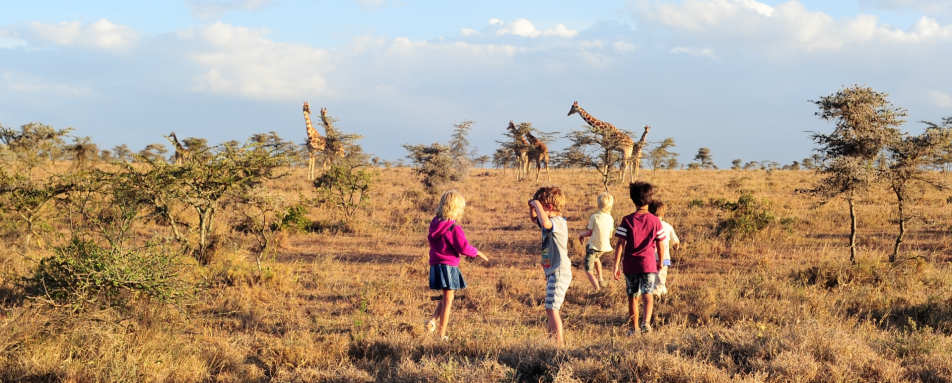 Kids playing in front of a herd of giraffe - El Karama Eco Lodge
