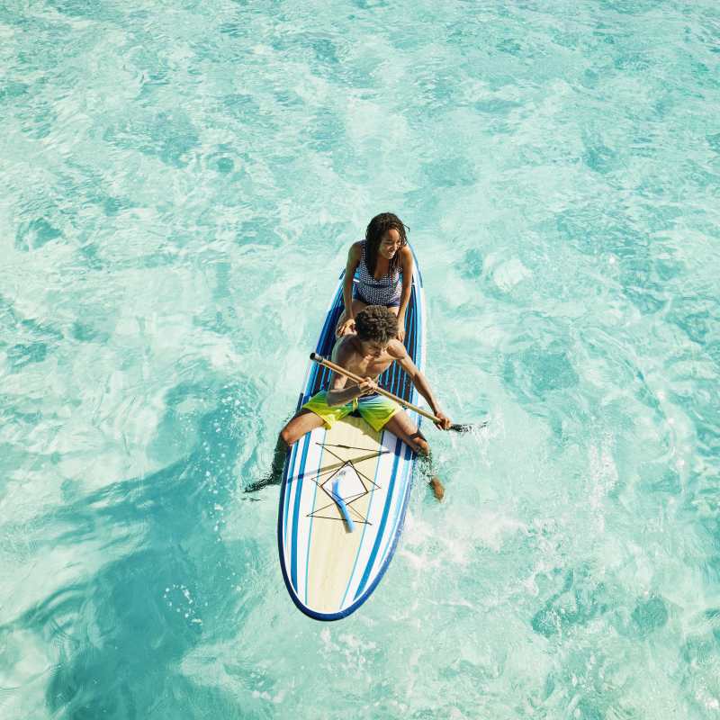 Teens paddleboarding on the water